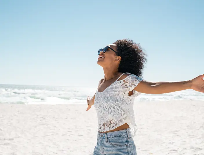 woman at beach with arms outstretched