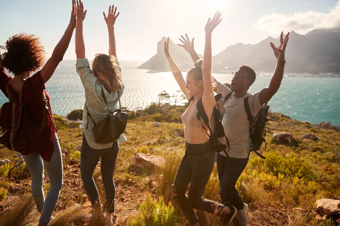 Happy friends on a bluff overlooking the ocean