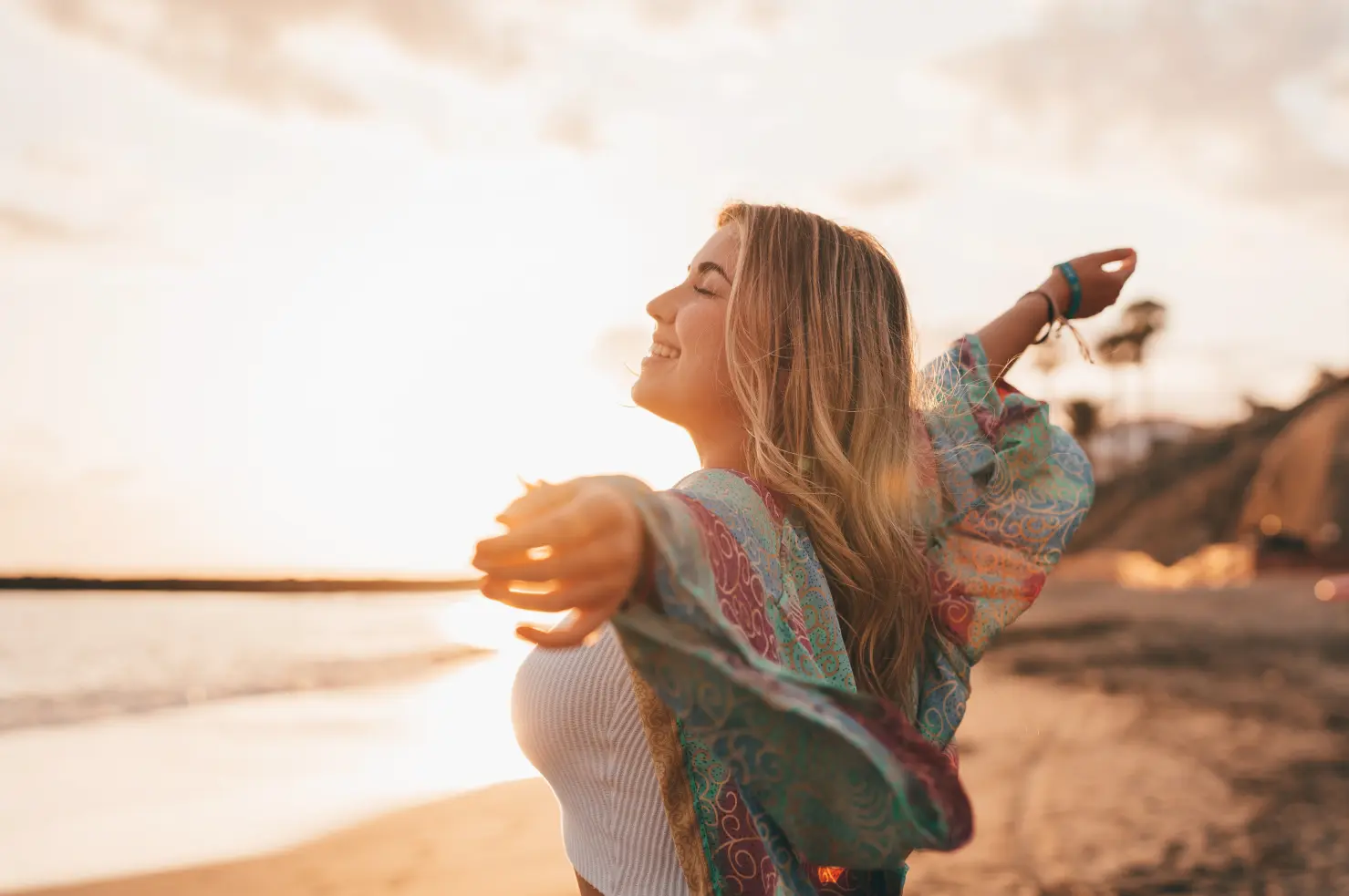 young woman at the beach with arms outstretched